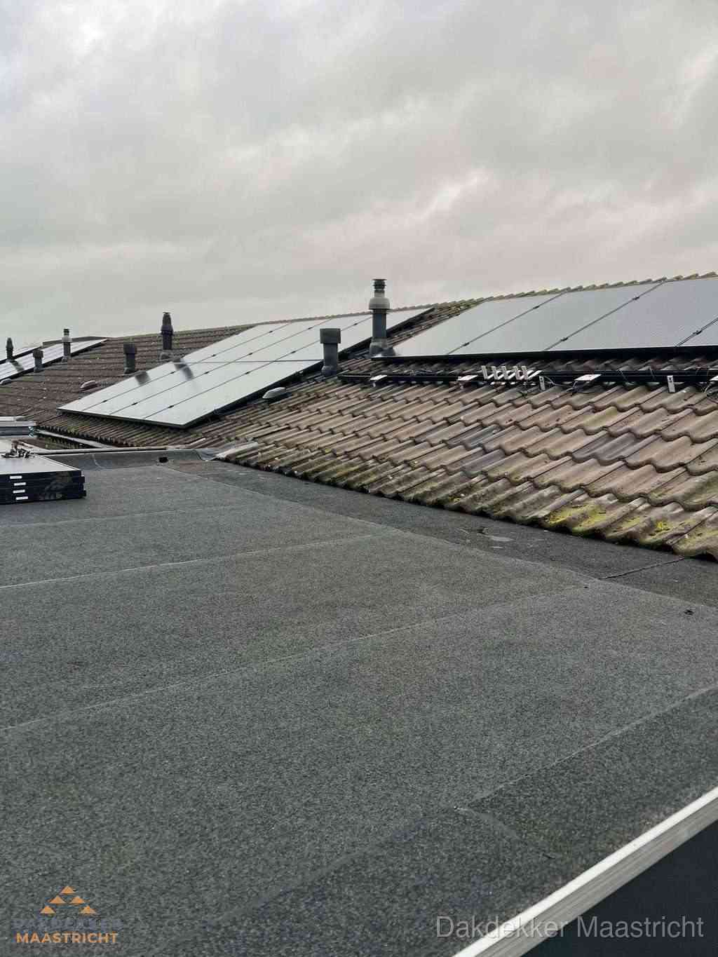 Plat dak inspectie met bitumen bedekking naast schuin pannendak in Maastricht