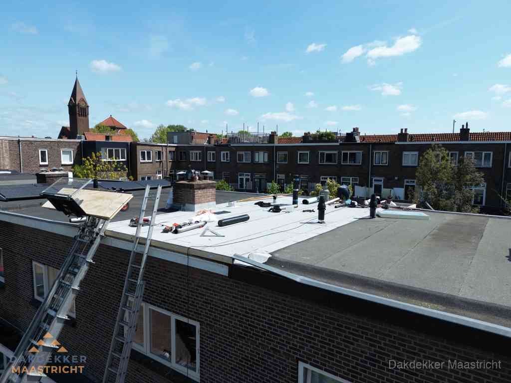 Dakdekkers aan het werk op plat dak in Maastricht