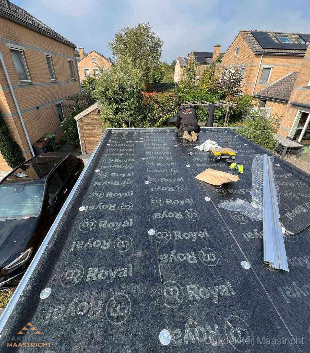 Dakdekker aan het werk op plat dak renovatie in Maastricht