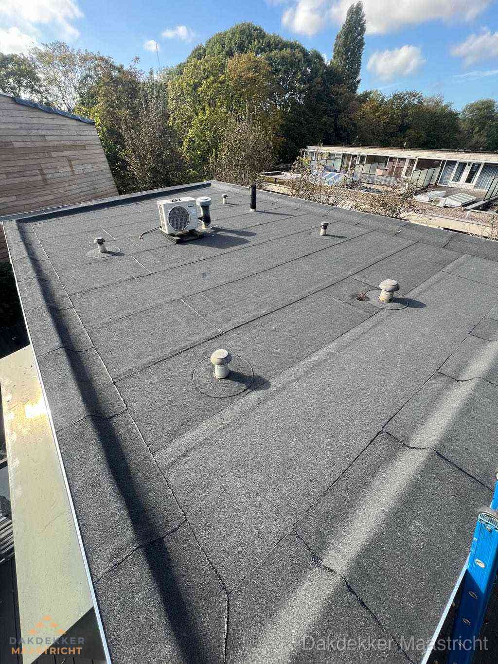 Plat dak met bitumen en brandgereedschap van dakdekkersbedrijf in Maastricht