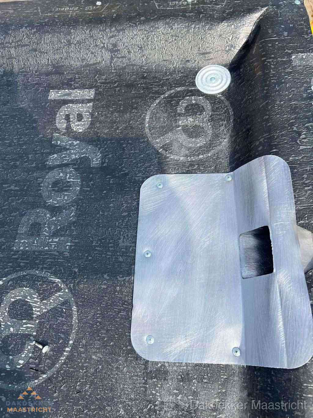 Dakdoorvoer met metalen afvoerplaat op bitumen dak in Maastricht
