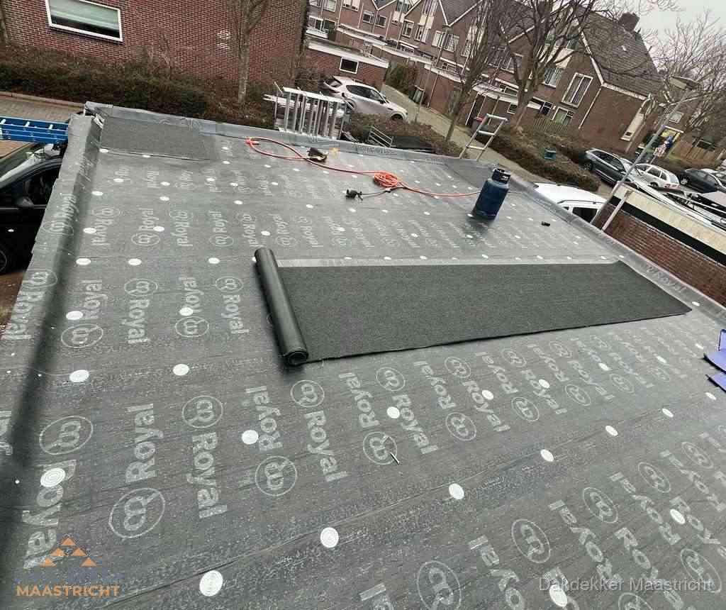 Dakdekker aan het werk met gasbrander op plat bitumen dak in Maastricht