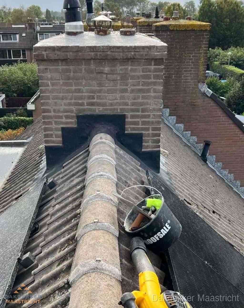 Dakdekker repareert bitumen dakleer bij dakdoorvoer in Maastricht